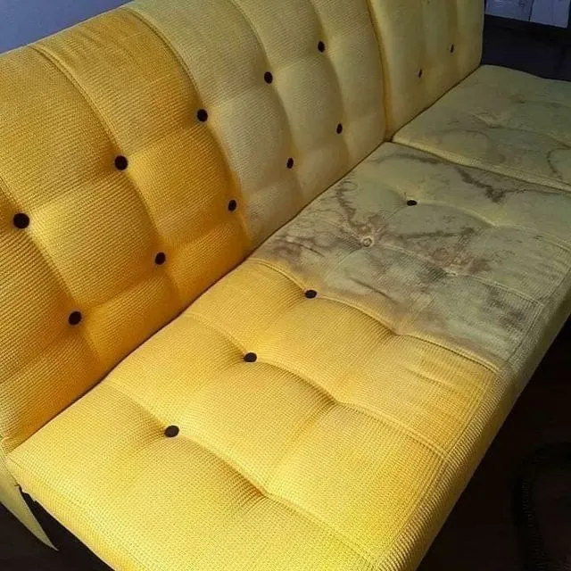 Yellow tufted sofa with a heavily stained seat cushion before treatment